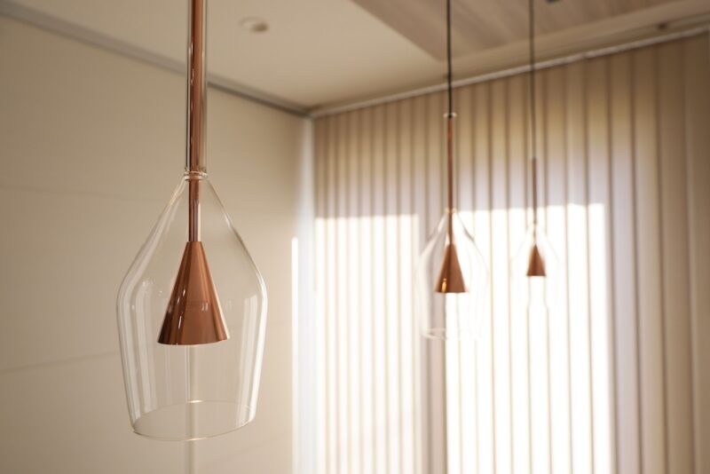 ダイニングテーブル上のダクトレールに設置された、コイズミ製のワイングラス風ペンダントライト（AP54866）3灯の様子。