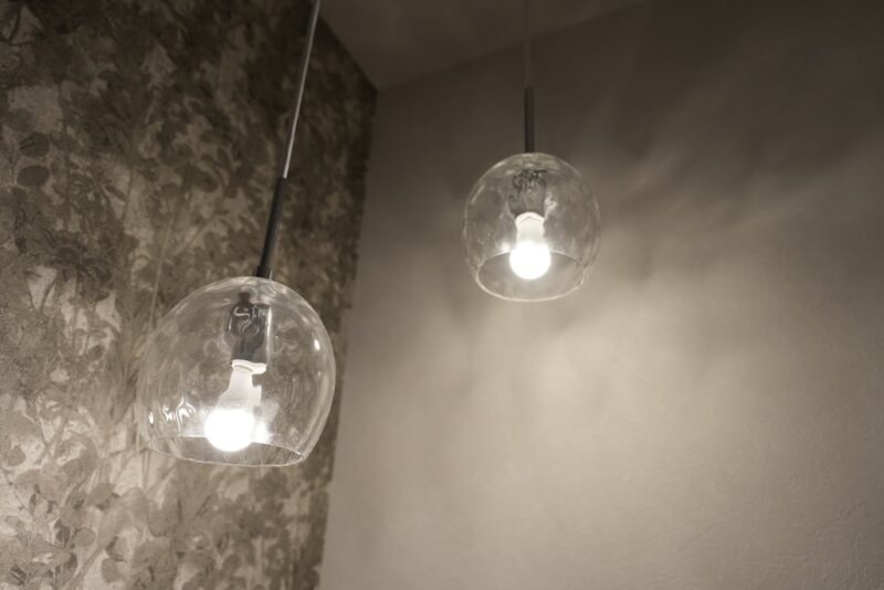 オーデリック製アクアシリーズのペンダントライト（OP252546LR）。1階トイレに2連で設置され、水面のような光の模様が壁に映っている様子。