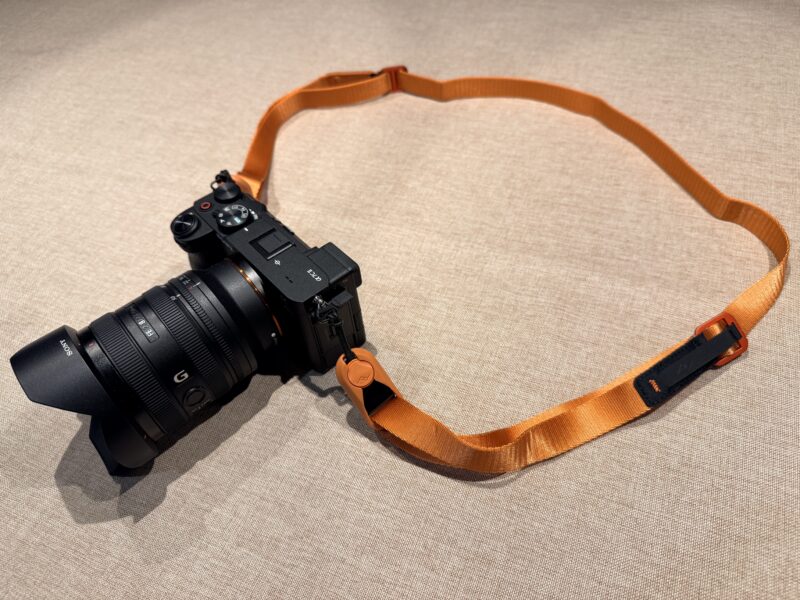 SONY α7C IIに装着されたピークデザインのリーシュ（アイビス/オレンジ色）。ブラックのカメラボディとの色の組み合わせが分かる写真。
