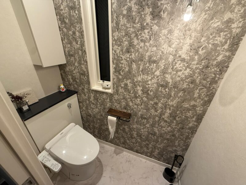 セキスイハイム1階トイレの実例。奥行き180cmの空間にサンゲツのアクセントクロス（RE55901）とオーデリック照明を施主支給したこだわり仕様。