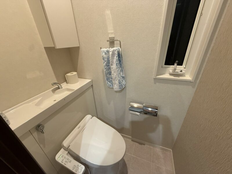 セキスイハイム2階トイレの標準仕様。TOTOのタンク付きトイレと標準クロスを採用しコストダウンした家族用トイレ。