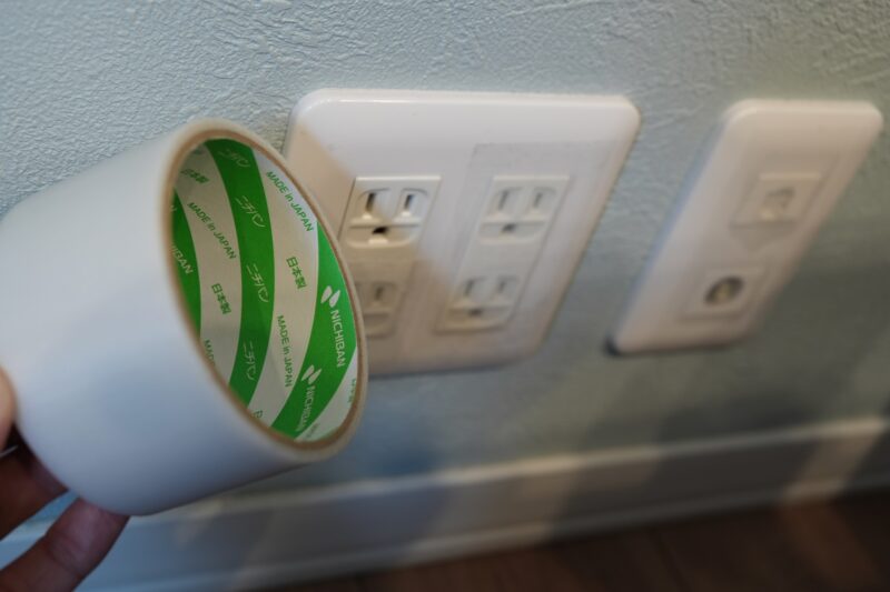 ニチバンの養生テープでコンセントまわりを目張りして、隙間風（冷気）対策をしている様子