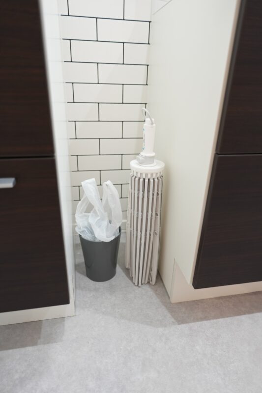 洗面台横27cm隙間の活用例 長尺物を押し込んで収納している様子