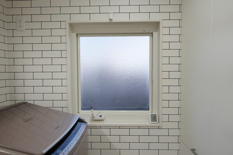 洗面所の大きな窓とサブウェイタイル風の壁紙
