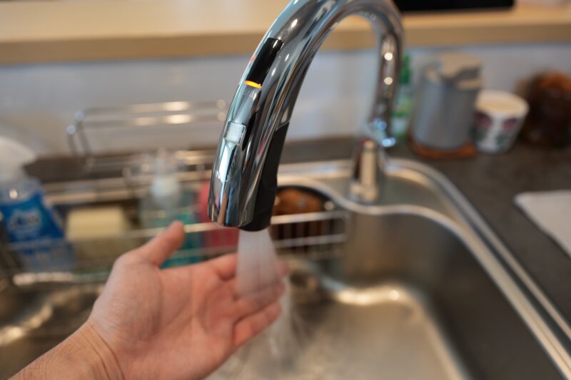 LIXILキッチンのタッチレス水栓に手をかざしている様子